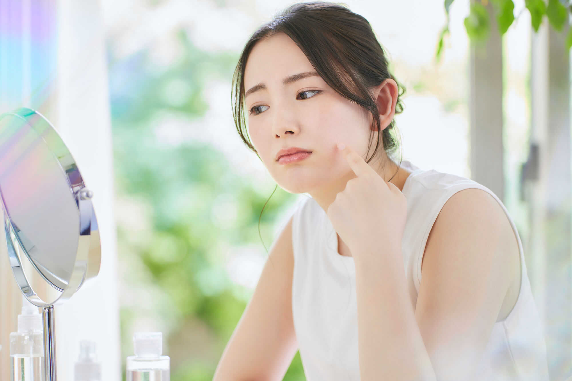 大阪梅田で顔の医療脱毛するならレナトゥスクリニック|効果・都度払い 19 顔の肌の状態を確認しながらスキンケアする女性