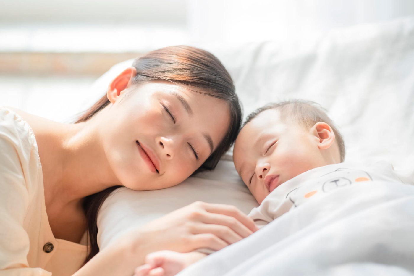 赤ちゃんと眠る母親