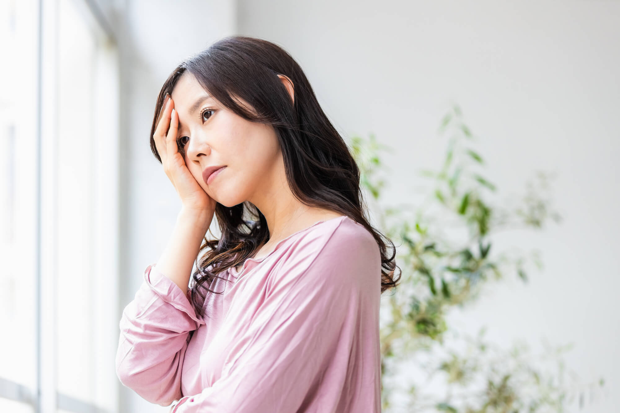 こめかみのヒアルロン酸注入 3 こめかみに手を当てて考える女性